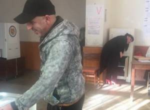 The same person casts his ballot wearing different clothes