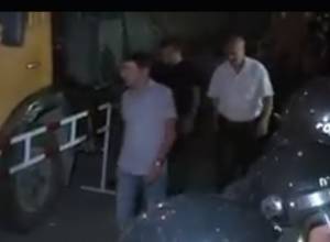 Plainclothes men pass behind police cordon on Khorenatsi street before Friday clashes