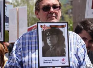 Ivan Volinkin and his mother participate in march in Yerevan, carrying the photo of his grandfather