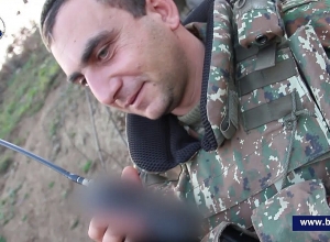 Подбадривающее сослуживцев исполнение солдата посредством радиосвязи