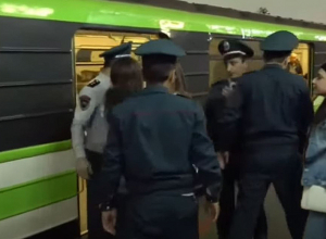 Полиция пытается отвести протестующих, сидящих между дверями метро